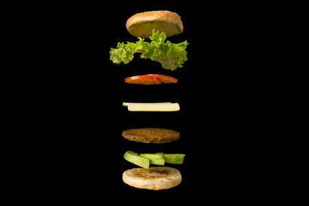 Five ingredient burger on black background.の写真素材