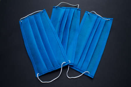 Three blue masks on black background.の写真素材