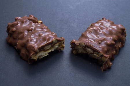 Delicious chocolate bar cut in half on black background.の写真素材