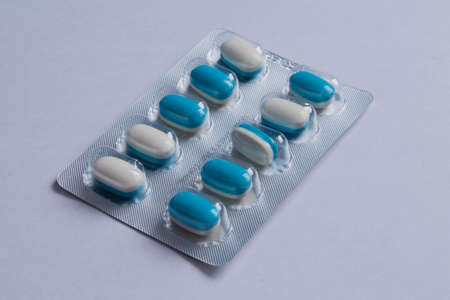 Blue and white capsules on a white background.の写真素材