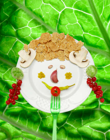 Funny and creative food plate on a lettuce background. playing with food
