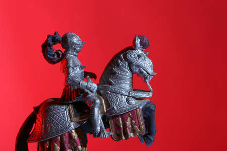 Equestrian medieval knight toy on red backgroundの写真素材