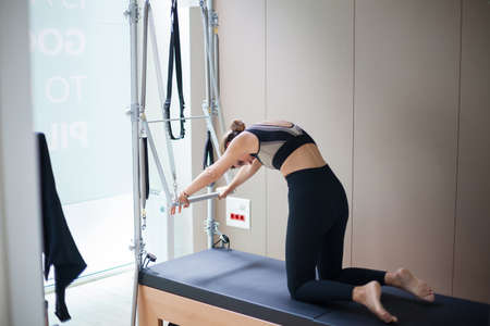 Attractive woman practicing pilates in reformer bedの写真素材