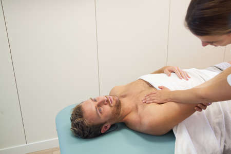 Female physiotherapist stretching man's armの写真素材