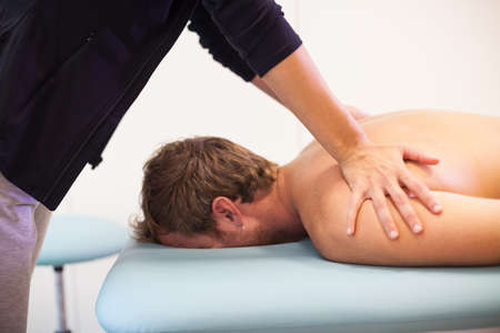 close up Female physiotherapist giving back massage to male patientの写真素材