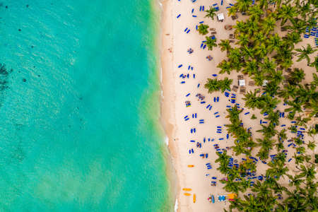 Aerial view of tourists during the summer in sun beds with umbrellas relaxing on a Caribbean beach, Bayahibe, Dominican Republicの写真素材