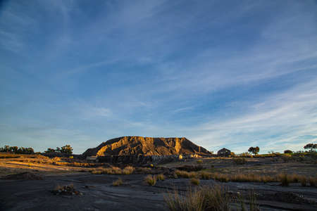 Abandoned mining operation with large coal dumps and village with dilapidated buildings