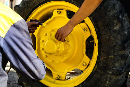 Yellow tractor wheel changeの写真素材