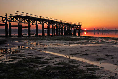 Low tide in the river, with motifs related to fishing activities, at the sunsetの写真素材