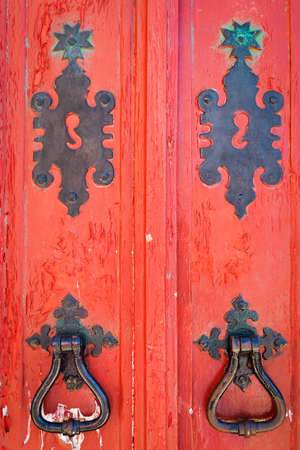 Old red doors with black ironmongeryの写真素材