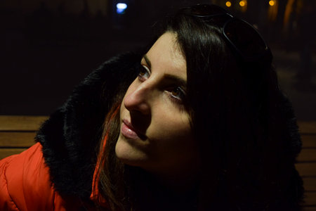 Portrait of a girl in a red jacket on the street at nightの写真素材