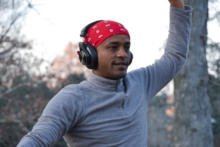 Young african american man listening to music with headphones outdoors.の写真素材