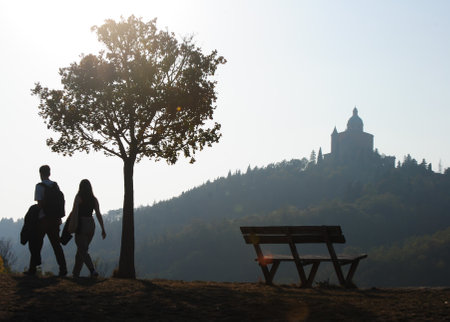 Silhouette of a couple on a hill with a church in the backgroundの写真素材