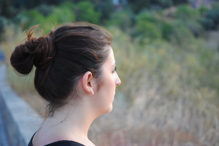 Young woman with a ponytail on the background of the village.の写真素材