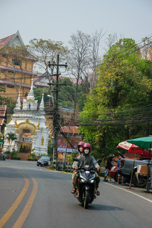 Traditional thai couple moving on motorbikeの写真素材