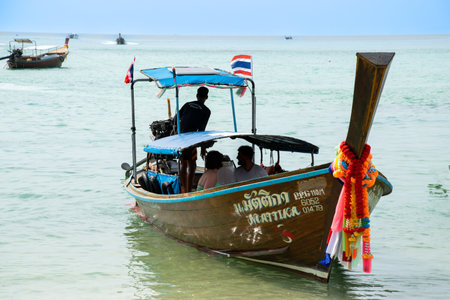 People entering on a longtail boat on vacationの写真素材