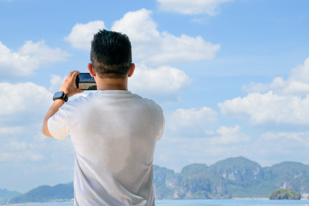 Adult man taking a photo in the islands on vacationの写真素材