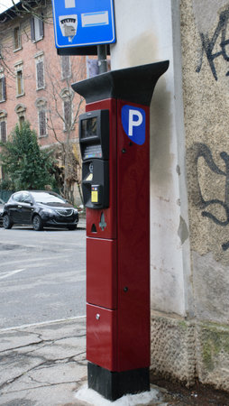 Red metal parquimeter on the street at Bologna, Italyの写真素材