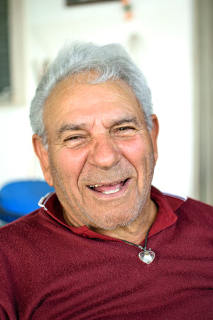 Grandfather with gray hair and red jersey smiling