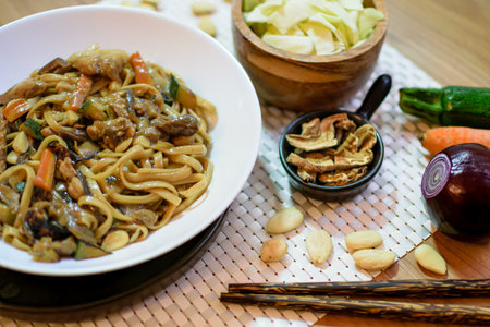 Rice noodles served with vegetables and meat in white bowl.の写真素材
