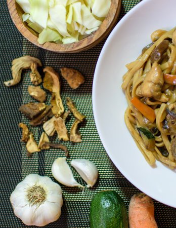 Rice noodles served with vegetables and meat in white bowl.の写真素材