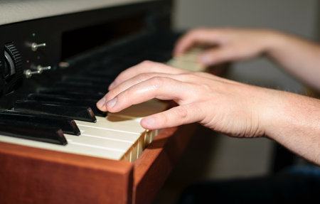 Close up view of Caucasian hands playing electric piano in bedroom