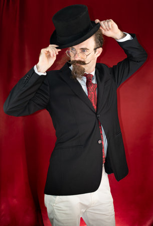 Vintage Caucasian Magician with top hat, glasses and mustache posingの写真素材