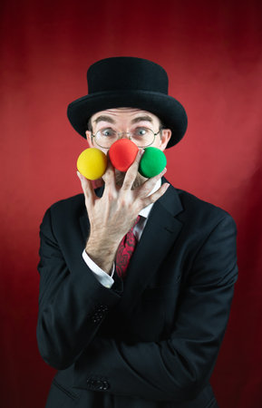 Vintage Caucasian Magician with top hat, glasses and mustache with colored ballsの写真素材