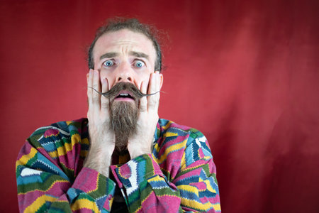 Hipster terrified man touching his face looking to camera with fear expressionの写真素材