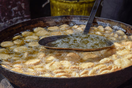 Traditional Namkeen Indian snacks and Samosas frying on street food and markets