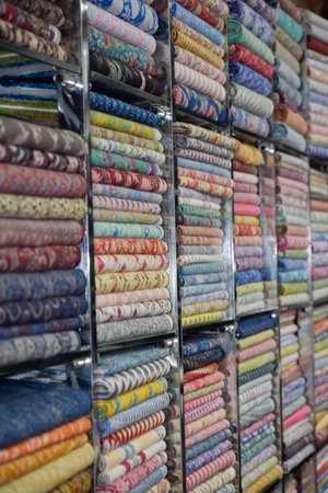 Indian textiles for saris with variety of colors shown in shop at local market