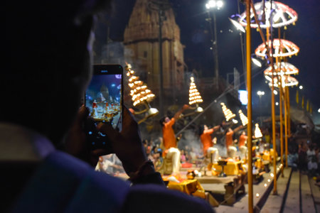 Pujaris or Indian priests performing Aarti ceremony on banks of Ganges in crowd