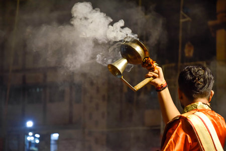 Pujaris or Indian priests performing Aarti ceremony on banks of Ganges in crowdの写真素材