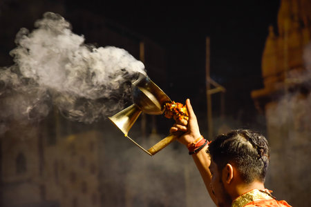 Pujaris or Indian priests performing Aarti ceremony on banks of Ganges in crowd