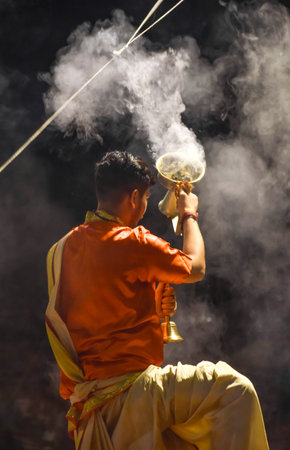 Pujaris or Indian priests performing Aarti ceremony on banks of Ganges in crowd