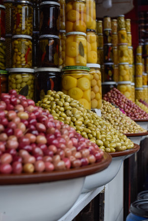 Different Olives displayed in local market with pickle jars in backgroundの写真素材