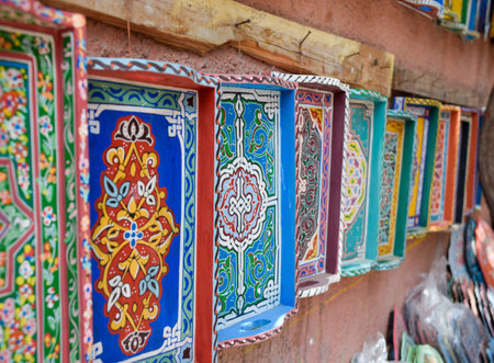 Colorful Hand-painted wooden trays and plates displayed in craft shop, Marrakechの写真素材