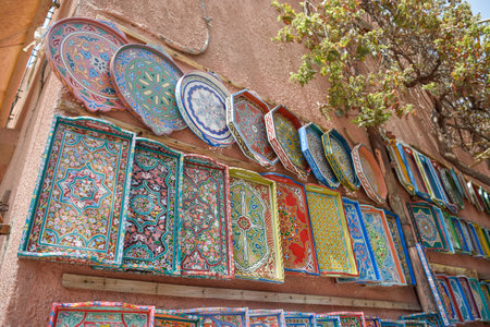 Colorful Hand-painted wooden trays and plates displayed in craft shop, Marrakechの写真素材