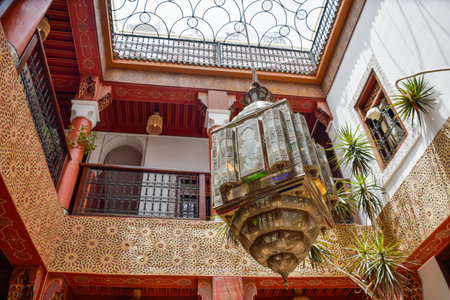 Typical Inner Courtyard Marrakech with red columns and a large colored lampの写真素材