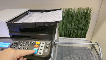 Close-Up of a Copier with Paper and Decorative Plant