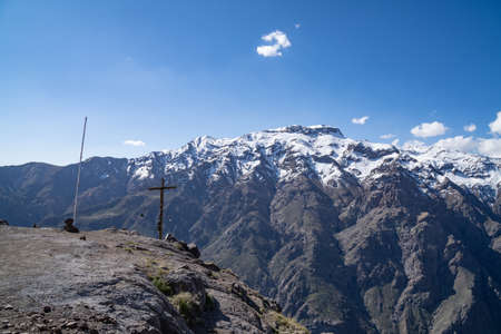 view of the snowy mountains of the andes mountain range with a blue sky and some clouds.