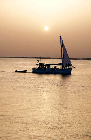 Recreation boat at sunset, in Ria Formosa, natural conservation region in Algarve, Portugal  の写真素材