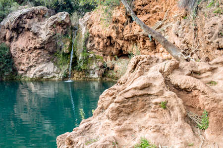 Beautiful waterfall with small lake in famous hidenn natural picnic rea called Pego do inferno Hells Pond near Tavira Algarve. Portugal.の写真素材