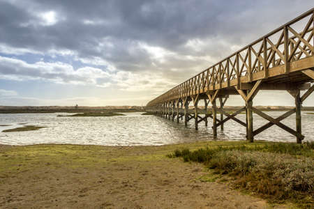 Landmark footbridge heading to famous Quinta do Lago beach in Ria Formosa wetlands natural conservation region landscape Algarve. Portugalの写真素材