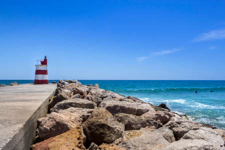Ocean view and small lighthouse in the inlet jetty of Tavira Island Algarve Portugal.の写真素材