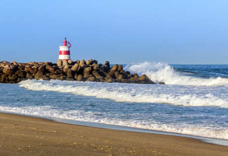 Ocean view and small lighthouse in the inlet jetty of Tavira Island Algarve Portugal.の写真素材