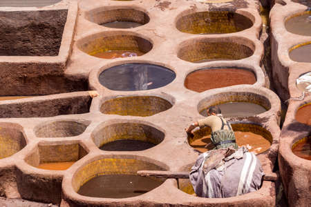Fes el Bali worker the dye pots at leather traditional tanneries in the ancient medina, in Fez, Morocco.のeditorial素材