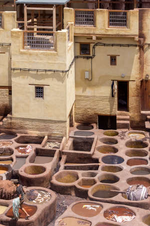 Fes el Bali worker the dye pots at leather traditional tanneries in the ancient medina, in Fez, Morocco.のeditorial素材
