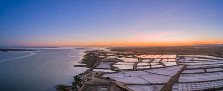 Sunset aerial panoramic view, in Ria Formosa wetlands natural park, salt production pans in the foreground, Algarve. Portugal.の写真素材