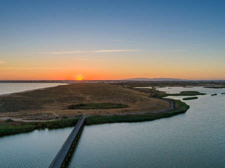 Aerial sunset seascape of Salgados beach and lagoon in Albufeira, Algarve tourism destination region, Portugal.の写真素材